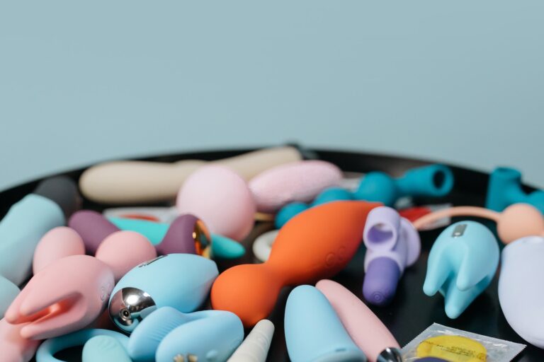 Multi-colored sex toys laid on a black tray.