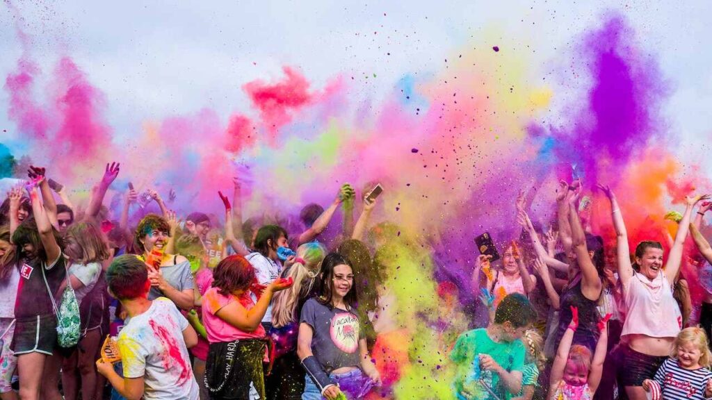 People celebrating the Hindu Festival, Holi, by throwing colored powder in the air.