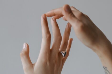 Two hands touch at the fingertips against a light gray background.