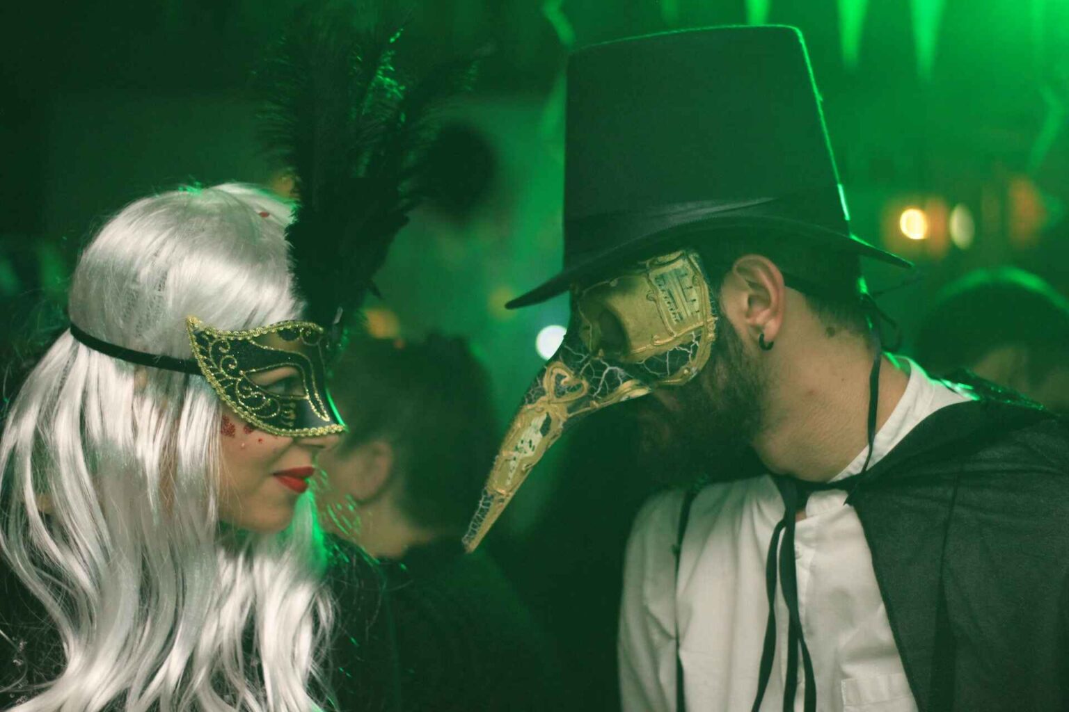 Costumed couple gazing at each other from behind their masks.