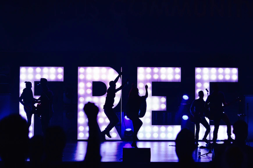 “Free” spelled out in LED letters behind people dancing, after getting orgasm tips.

