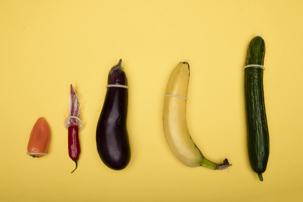 A variety of fruit and vegetables with condoms slipped over them.