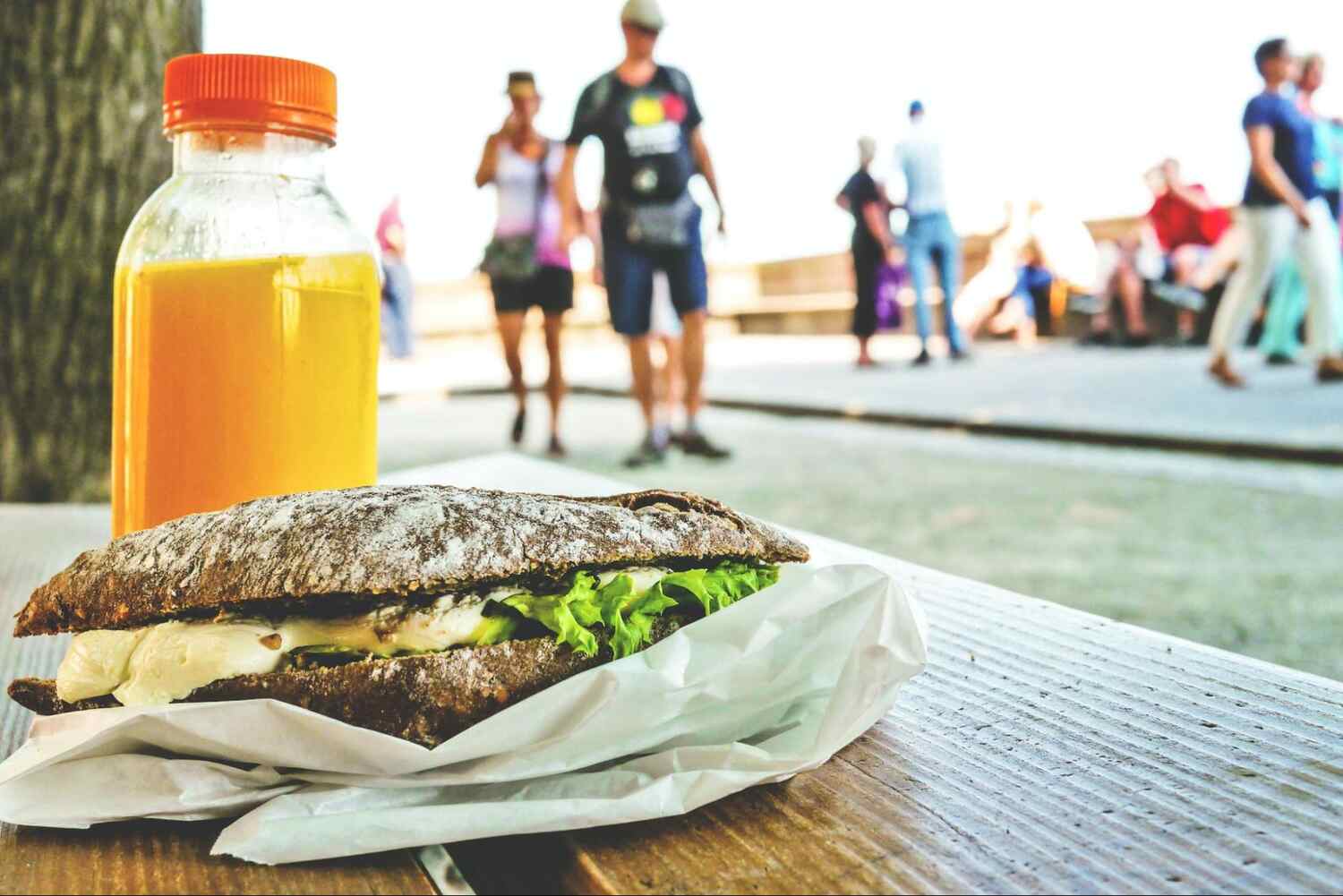 A sandwich and bottle of orange juice on a table